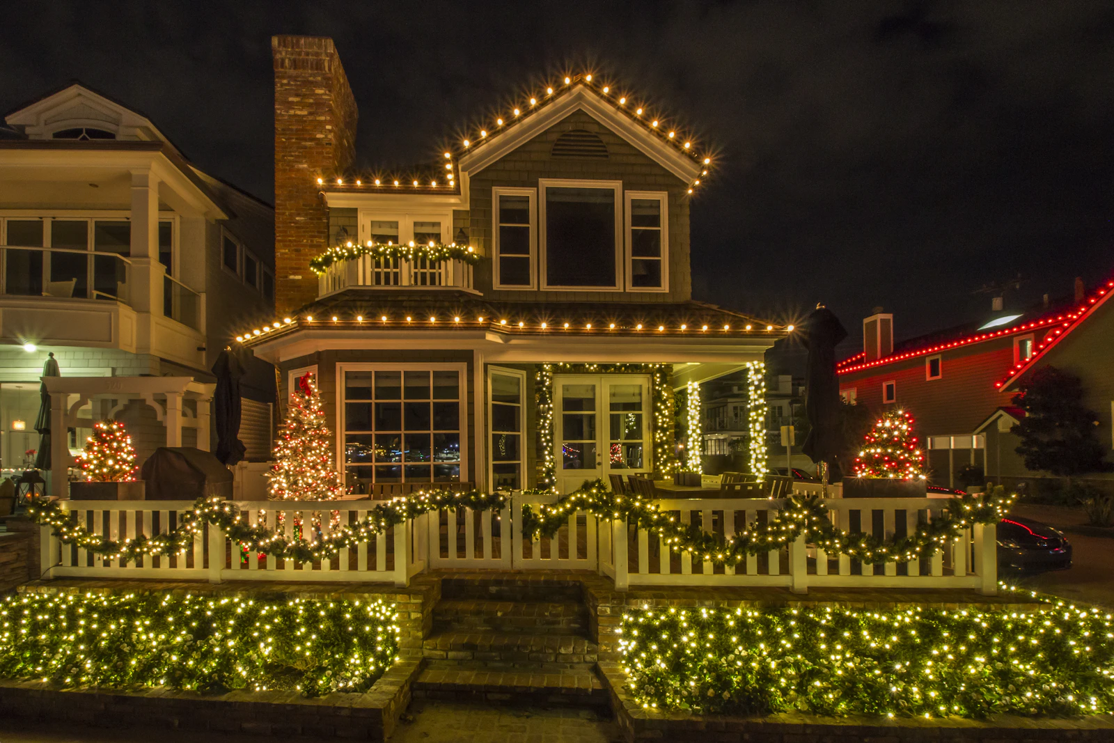 Warm white Christmas lights outlining a house, porch and front garden